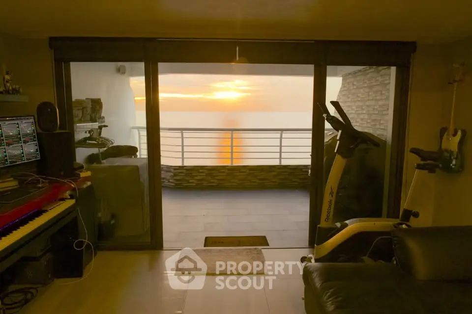 Stunning living room with balcony offering breathtaking sunset views, perfect for relaxation and entertainment.