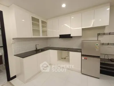 Modern kitchen with sleek white cabinets and stainless steel appliances