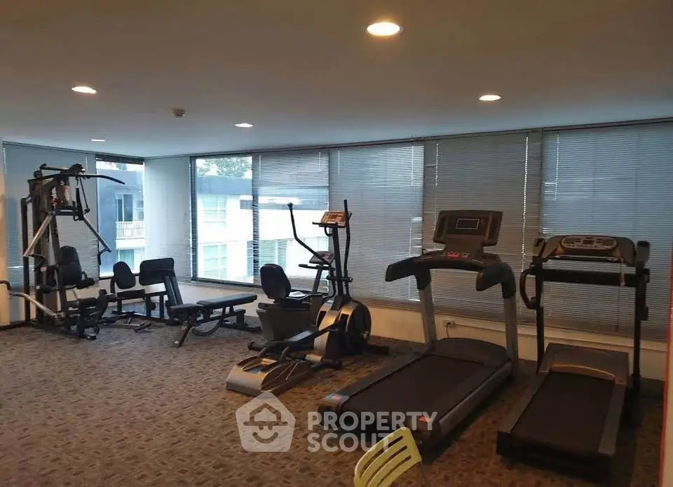 Spacious gym with modern fitness equipment in a residential building.