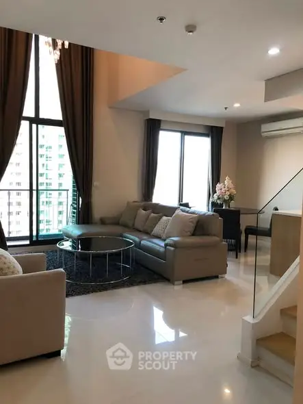 Spacious modern living room with high ceilings and large windows in a luxury apartment.