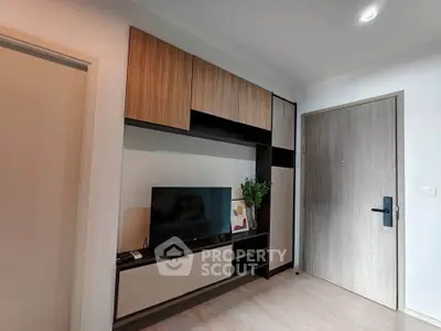 Modern living room with sleek wooden cabinetry and flat-screen TV, perfect for cozy relaxation.