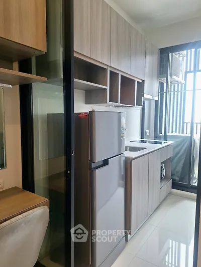 Modern kitchen with sleek cabinetry and stainless steel appliances in a stylish apartment.
