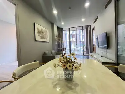 Modern living room with stylish decor and large windows offering natural light and a view of the balcony.