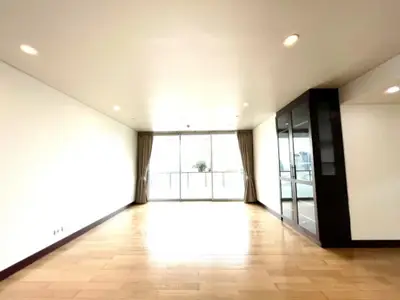 Spacious living room with large windows and wooden flooring in modern apartment