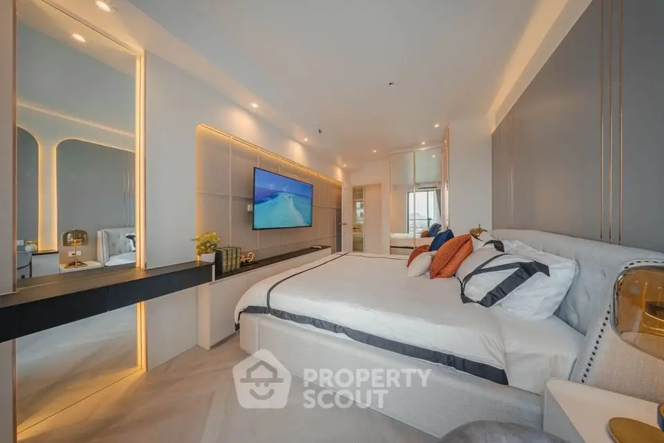 Luxurious modern bedroom with elegant decor and ambient lighting, featuring a large bed and wall-mounted TV.