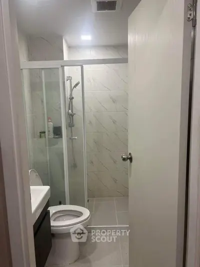 Modern bathroom with glass shower and sleek fixtures in a contemporary home.