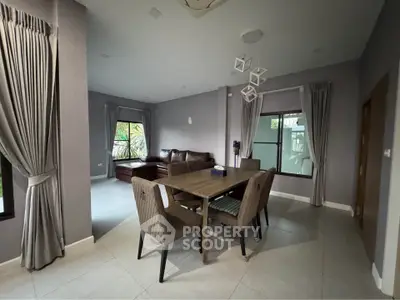 Spacious dining area with modern decor and large windows in a stylish home.