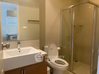 Modern bathroom with glass shower and sleek vanity in a contemporary home.