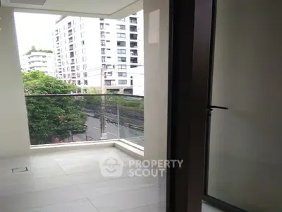 Modern apartment balcony with glass railing and city view