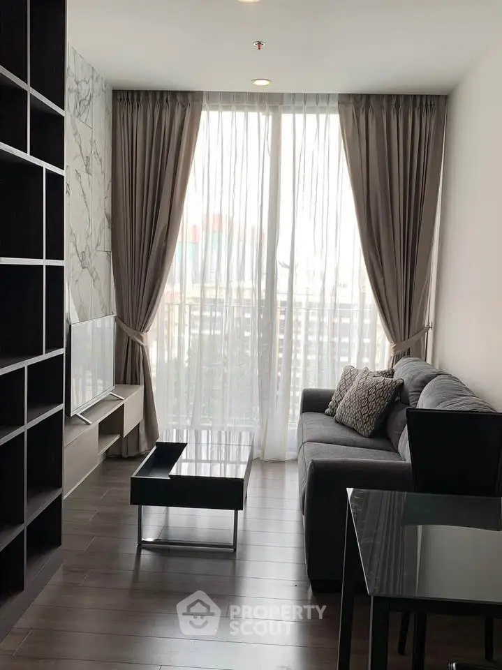 Modern living room with floor-to-ceiling windows and elegant decor in a high-rise apartment.