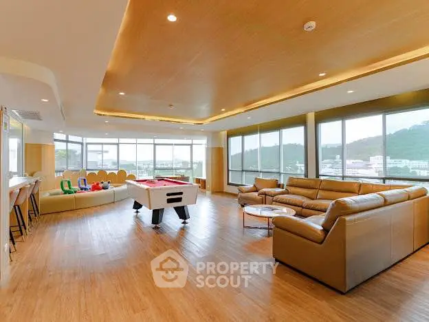 Spacious modern living room with panoramic windows and game area