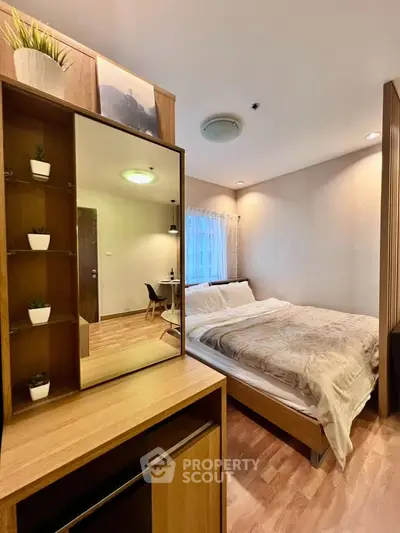 Cozy bedroom with modern decor and natural light, perfect for relaxation.