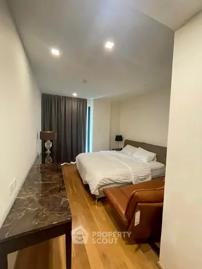 Modern bedroom with cozy bed, elegant lighting, and stylish decor in a contemporary apartment.