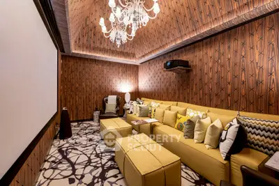 Luxurious home theater with plush seating and elegant chandelier