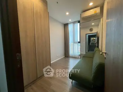 Modern apartment interior with sleek wooden flooring and stylish green sofa
