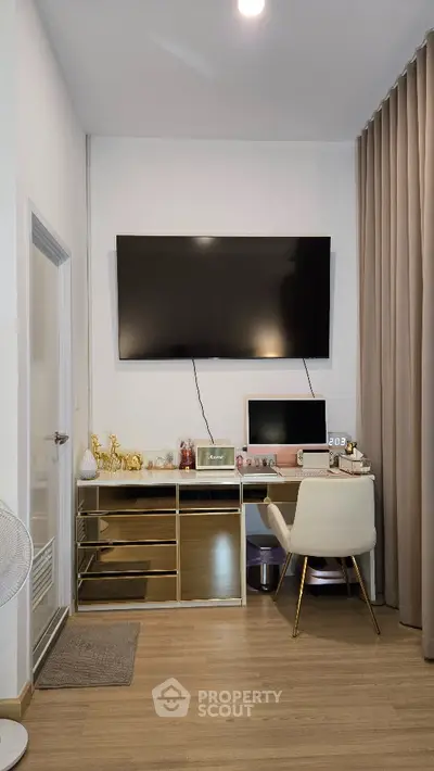 Modern study room with sleek desk, large TV, and elegant decor