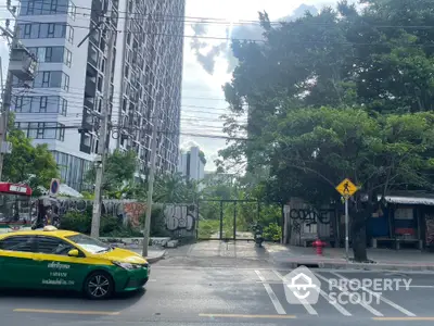 Urban street view with modern high-rise building and lush greenery