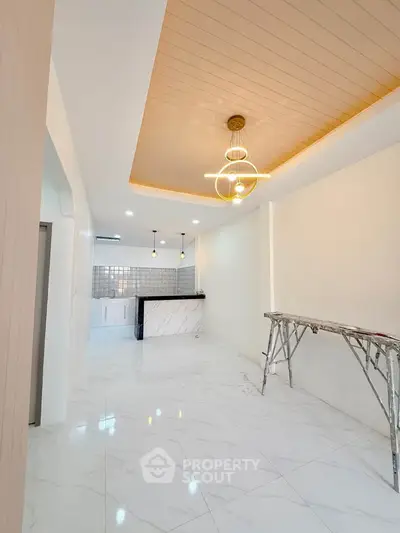 Modern open layout kitchen with stylish lighting and marble flooring