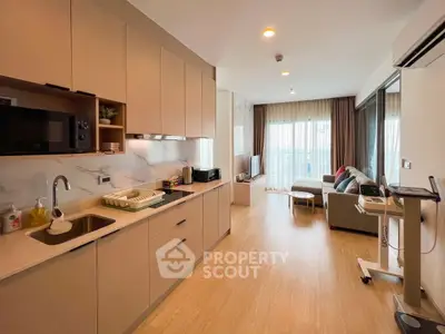 Modern open-layout kitchen and living room with natural light and stylish decor.