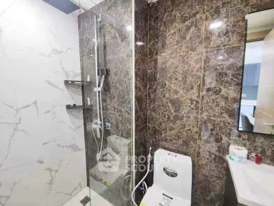Modern bathroom with marble tiles and glass shower enclosure