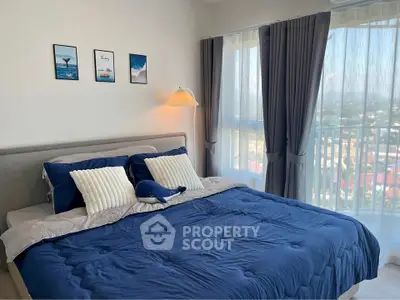 Cozy bedroom with modern decor and large windows offering a stunning view.