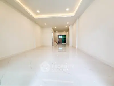 Spacious modern interior with glossy white tiles and recessed lighting, perfect for customization.
