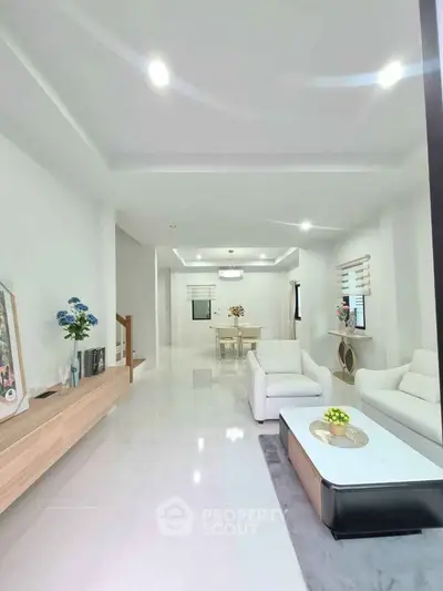 Spacious modern living room with elegant white furniture and open dining area