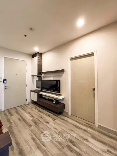 Modern living room with stylish TV unit and wood flooring, perfect for cozy entertainment.