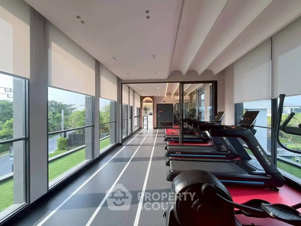 Modern gym with treadmills and large windows offering scenic views, perfect for fitness enthusiasts.