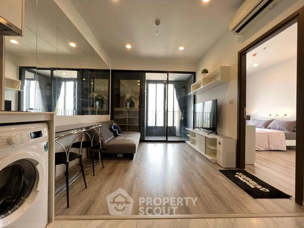 Modern living room with washing machine and balcony access, open layout design, and stylish decor.