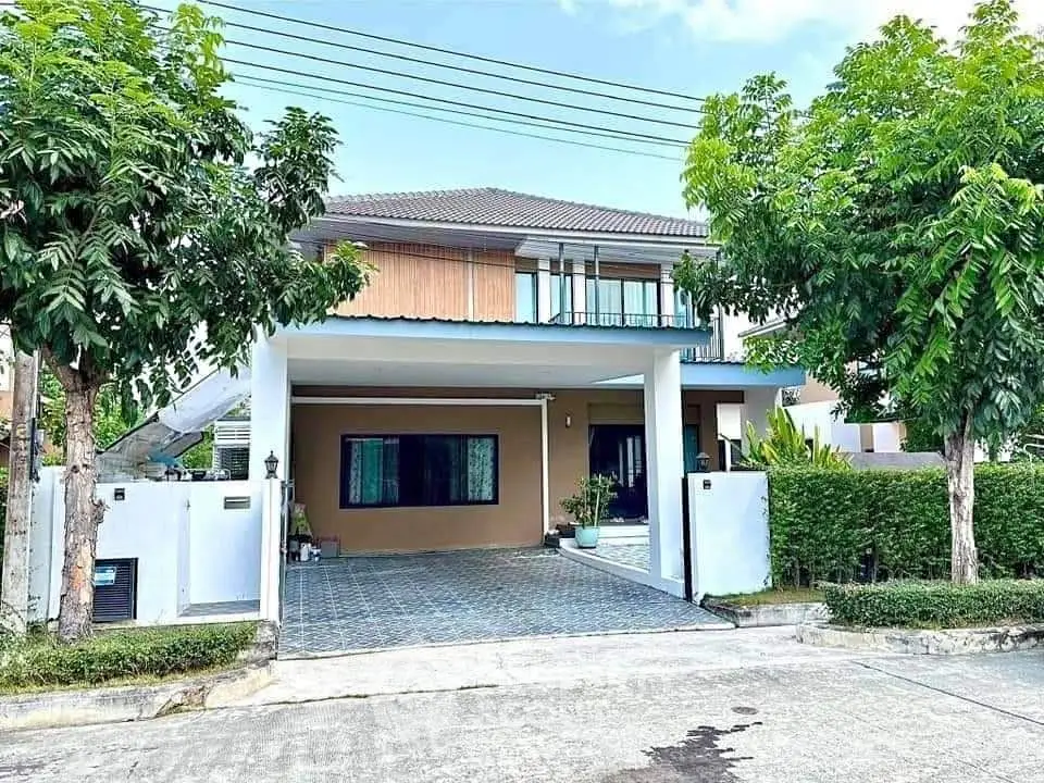 Charming two-story house with lush greenery and spacious driveway