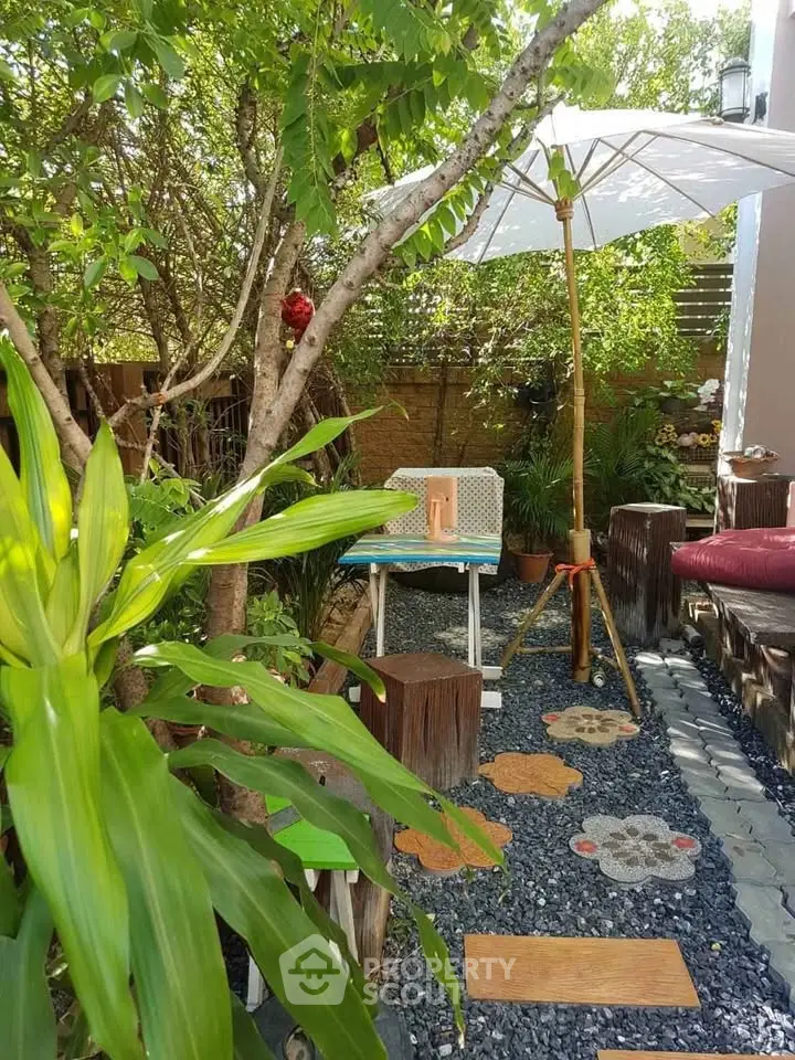 Charming garden oasis with lush greenery and cozy seating area, perfect for relaxation and outdoor enjoyment.