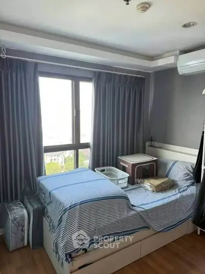 Cozy bedroom with large window and modern decor in urban apartment