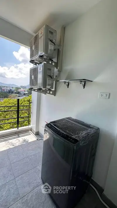 Modern balcony with washing machine and scenic view, perfect for urban living.