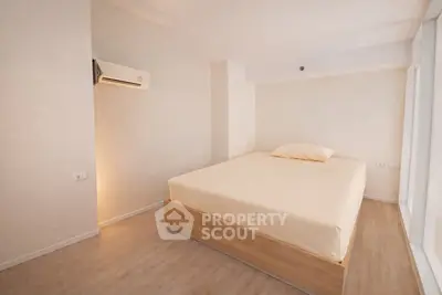 Minimalist bedroom with wooden flooring and air conditioning