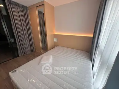 Modern bedroom with stylish lighting and large window, featuring a comfortable bed and sleek wardrobe.