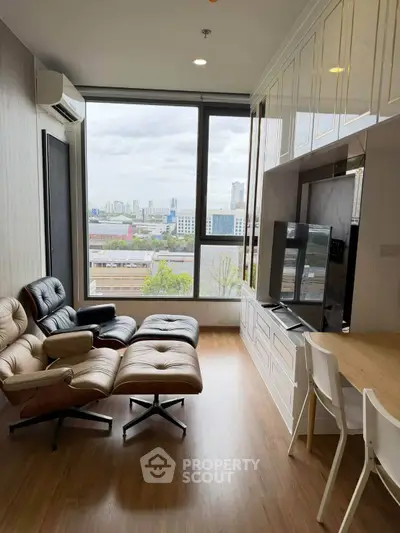 Modern living room with city view, featuring stylish furniture and large windows for natural light.