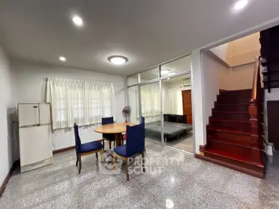 Spacious living area with dining set and staircase in modern home