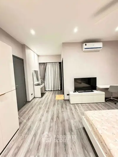 Modern bedroom with sleek flooring, air conditioning, and stylish furniture