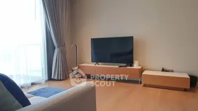 Modern living room with sleek TV setup and elegant curtains, perfect for relaxation.