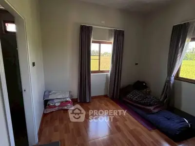 Minimalist bedroom with wooden flooring and natural light