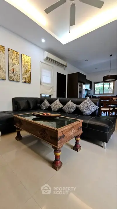 Spacious living room with modern decor and open kitchen layout, perfect for entertaining guests.