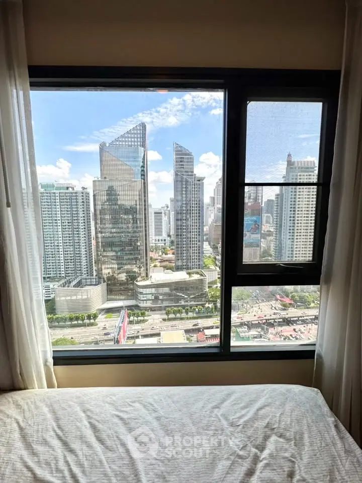 Stunning cityscape view from a modern bedroom window in a high-rise apartment.