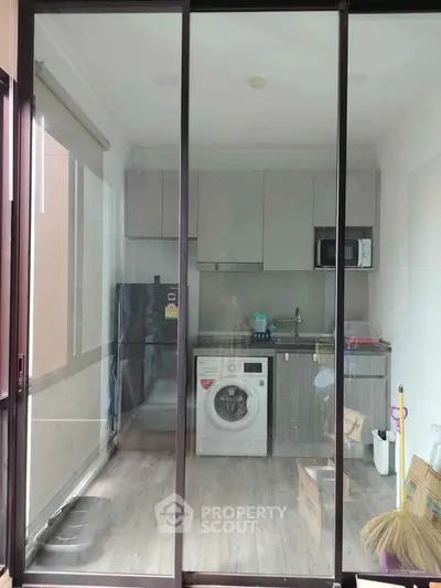 Modern kitchen with washing machine and sleek cabinetry in a compact layout.