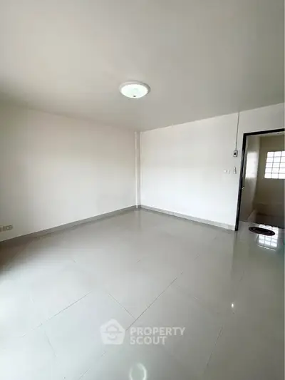 Spacious empty room with glossy tiled floor and bright lighting, ideal for customization.