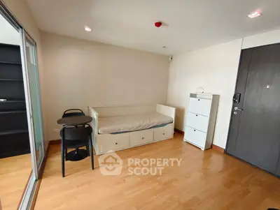 Cozy bedroom with wooden flooring and minimalist furniture in modern apartment.