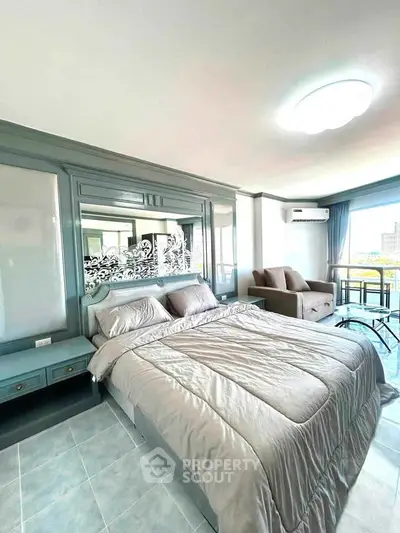 Spacious bedroom with modern decor and large windows offering natural light and city views.