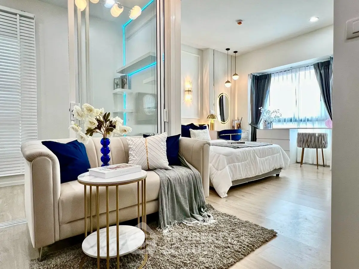 Luxurious modern living room with elegant decor and cozy bedroom in open layout apartment.