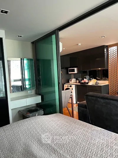 Modern studio apartment with sleek kitchen and cozy living area, featuring contemporary design and stylish furnishings.