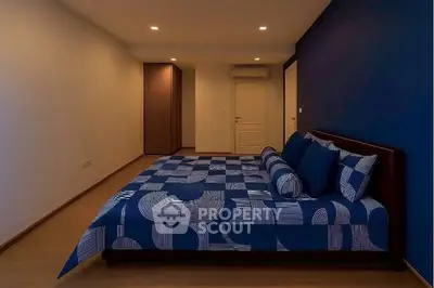 Spacious bedroom with modern blue decor and ample lighting